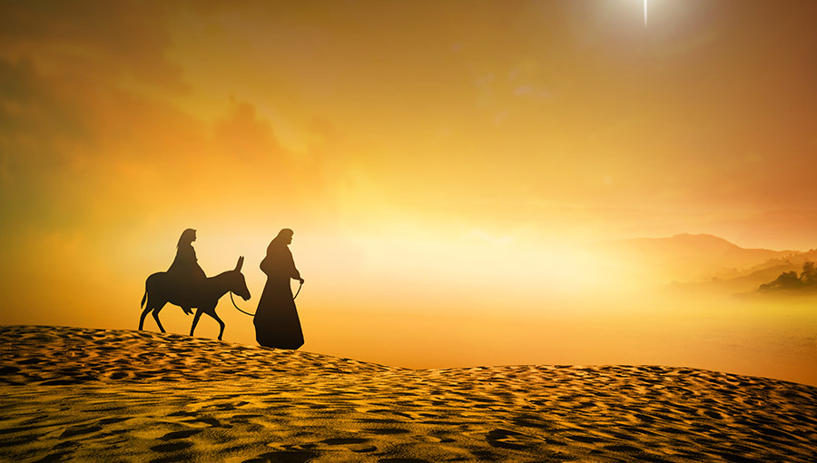 Christmas religious nativity concept: Silhouette pregnant Mary and Joseph with a donkey on Christmas eve background