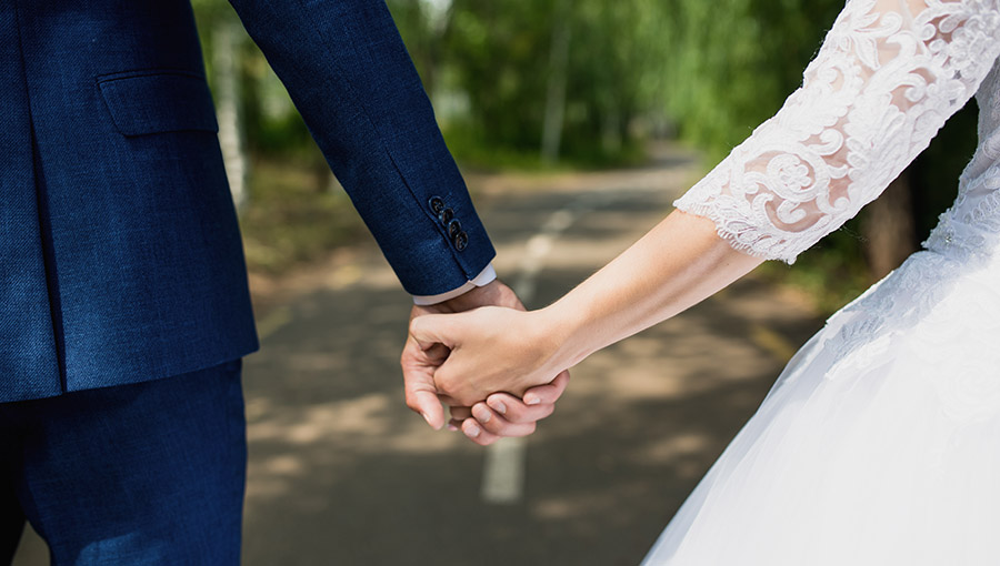 the bride and groom hold hands