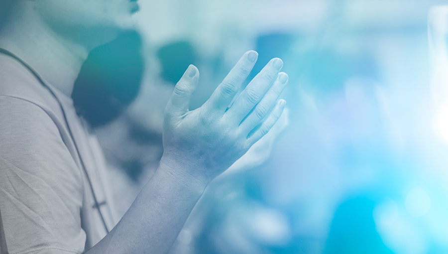 Man praying and worship to GOD in Church.Man raised hands and pray to GOD.Hand praying and palmup,Concept Praise and worship with faith, spirituality and Surrender.