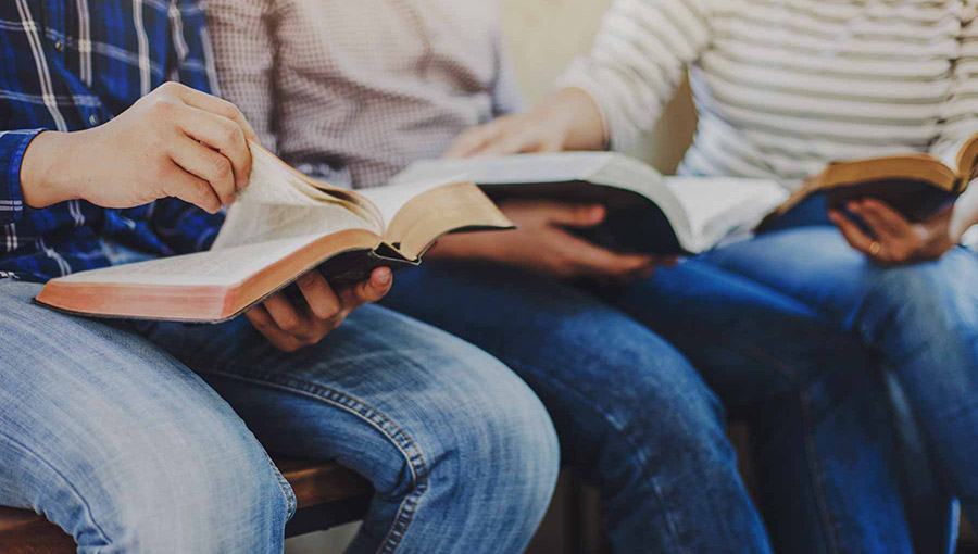 close up of christian group hold and opening bible page while reading and study bible together with friends in Sunday school class room