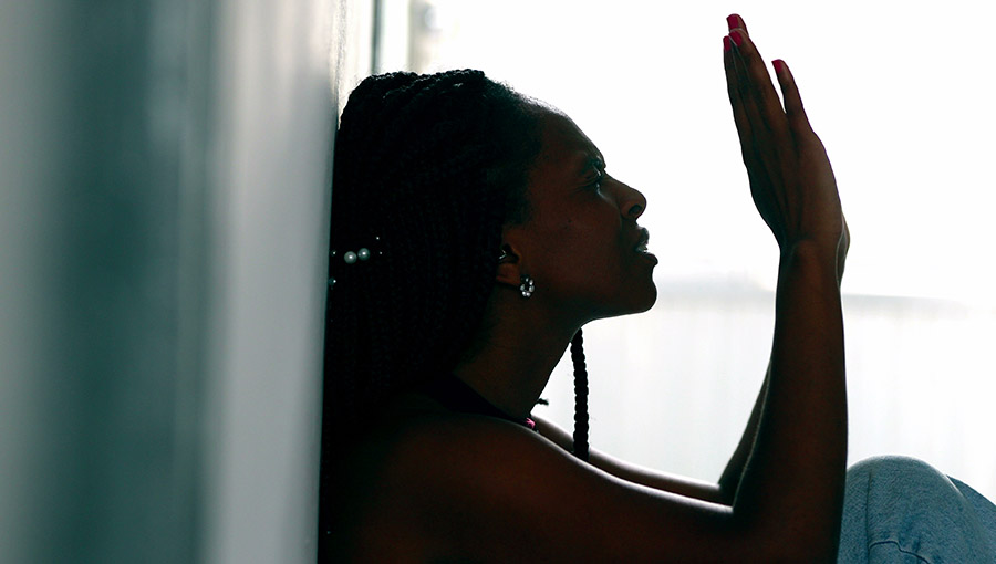 Religious African woman seeking divine help during struggling times, silhouette black female praying