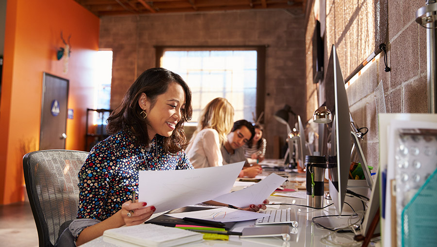 Team Of Designers Working At Desks In Modern Office